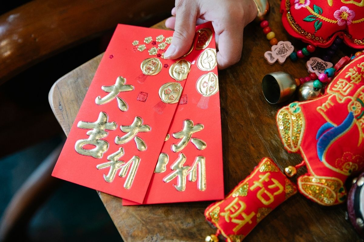 Woman with Chinese red envelope and decor for New Year