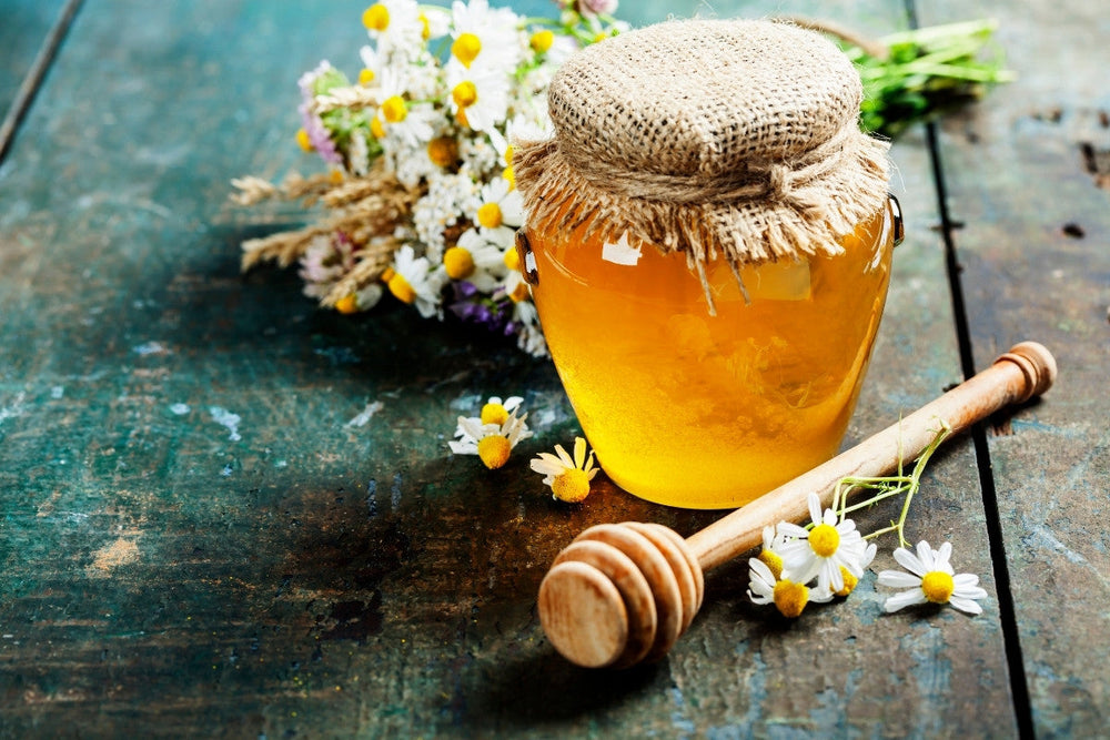 honey jar surrounded by flowers used as honey wedding favors