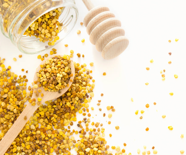 bee pollen in a jar and wooden spoon