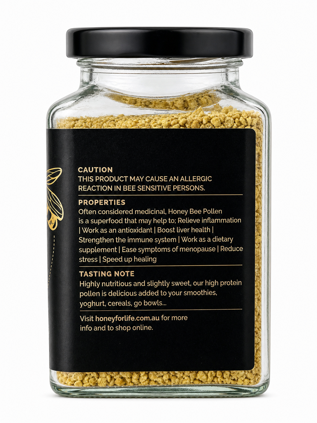 A clear glass jar filled with yellow honey bee pollen granules, featuring a black screw-on lid and a black label with white text and a small gold bee illustration. The back of the label displays product information and a tasting note.