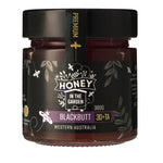 A jar of Blackbutt honey with a label that includes the brand name, product name, and the brand name 'Honey in the Garden'. 
